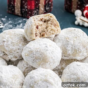 A pile of snowball cookies with a bite taken from one to show texture.