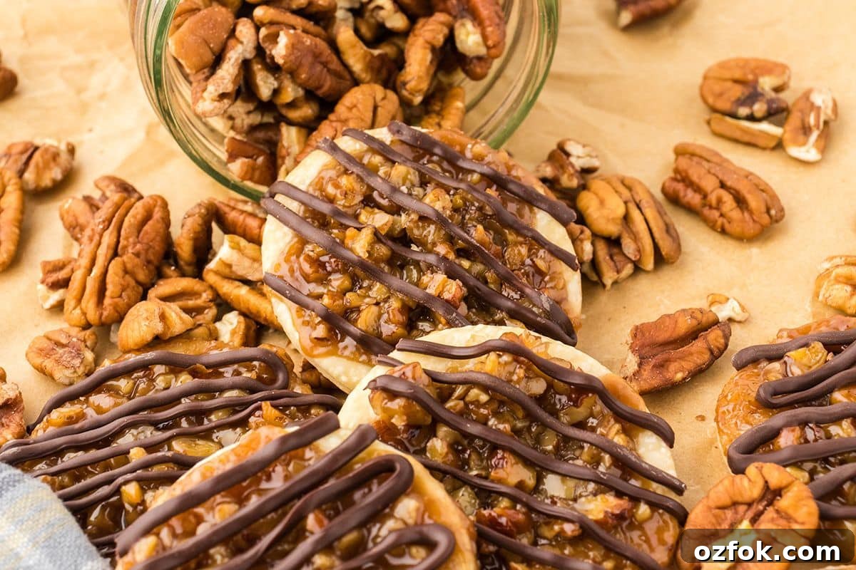 Pecan Pie Cookie Recipe: Chewy Cookies with Cinnamon Glaze 5 Pecan pie cookies on a brown parchment paper with pecans on the table.