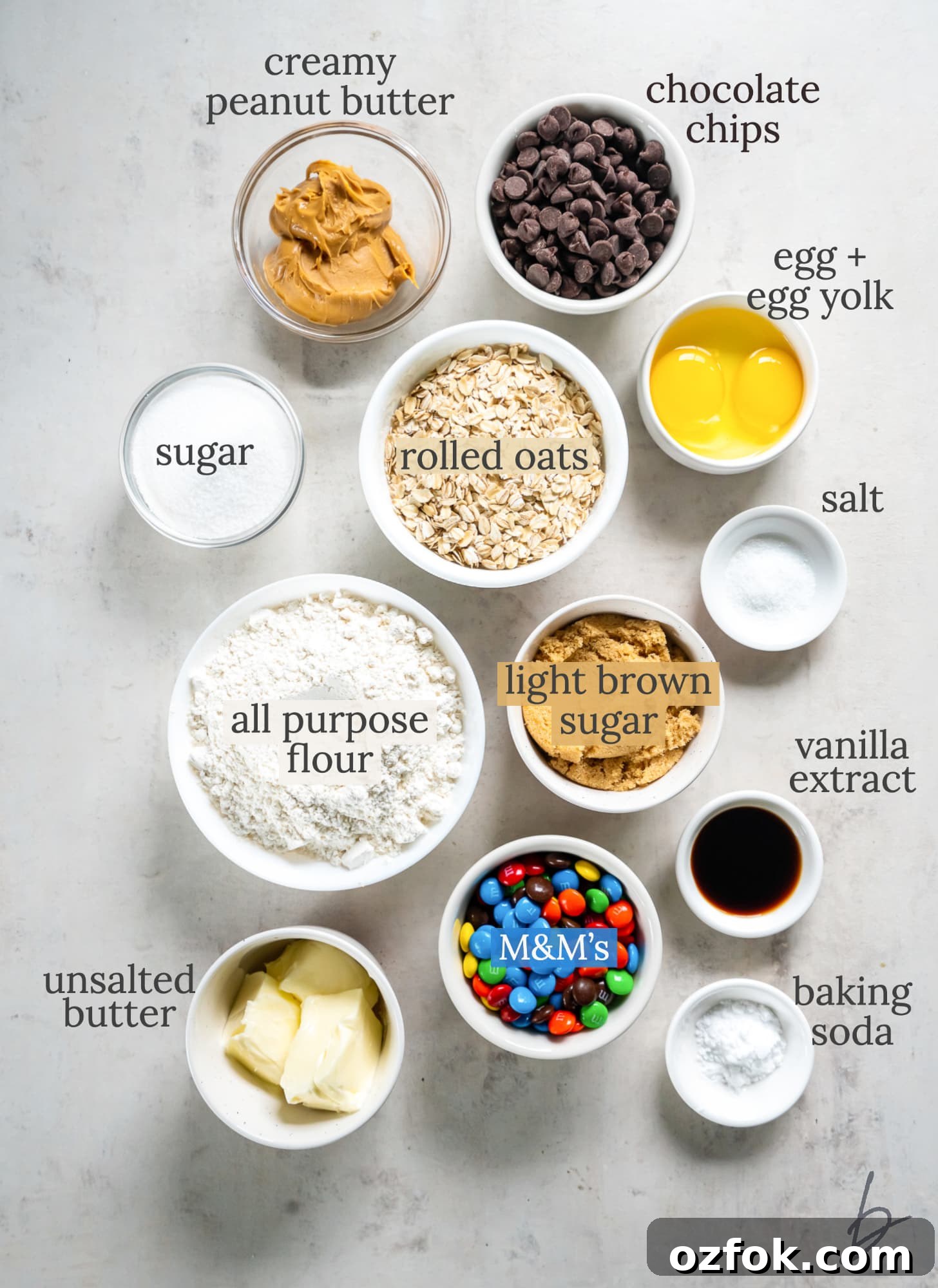 Chewy Monster Cookie Bars Recipe with Chocolate Chips and M&Ms 3 monster cookie bars ingredients in bowls labeled with text.