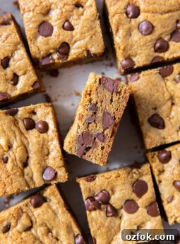 tops of chocolate chip cookie bars with one bar turned on its side to show chocolate chips inside