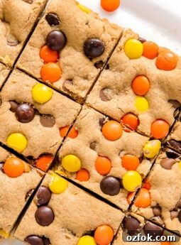 reeses pieces peanut butter blondies cut into squares on parchment paper