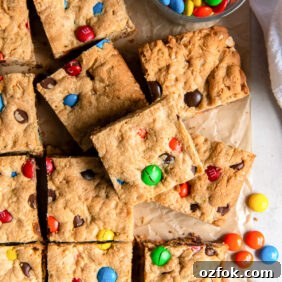 Chewy Monster Cookie Bars Recipe with Chocolate Chips and M&Ms 10 square monster cookie bar on top of more bars with m&ms.