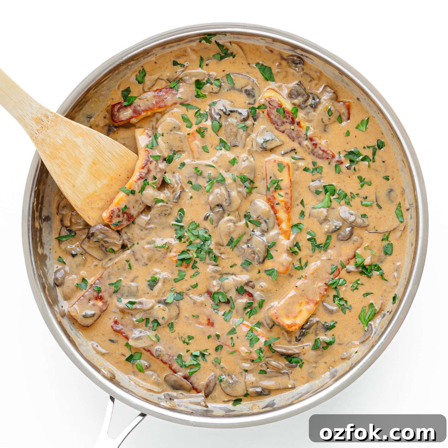 Creamy Halloumi Stroganoff with Mushrooms and Thyme 9 Halloumi Stroganoff in a stainless steel pan being stirred with a wooden spoon.