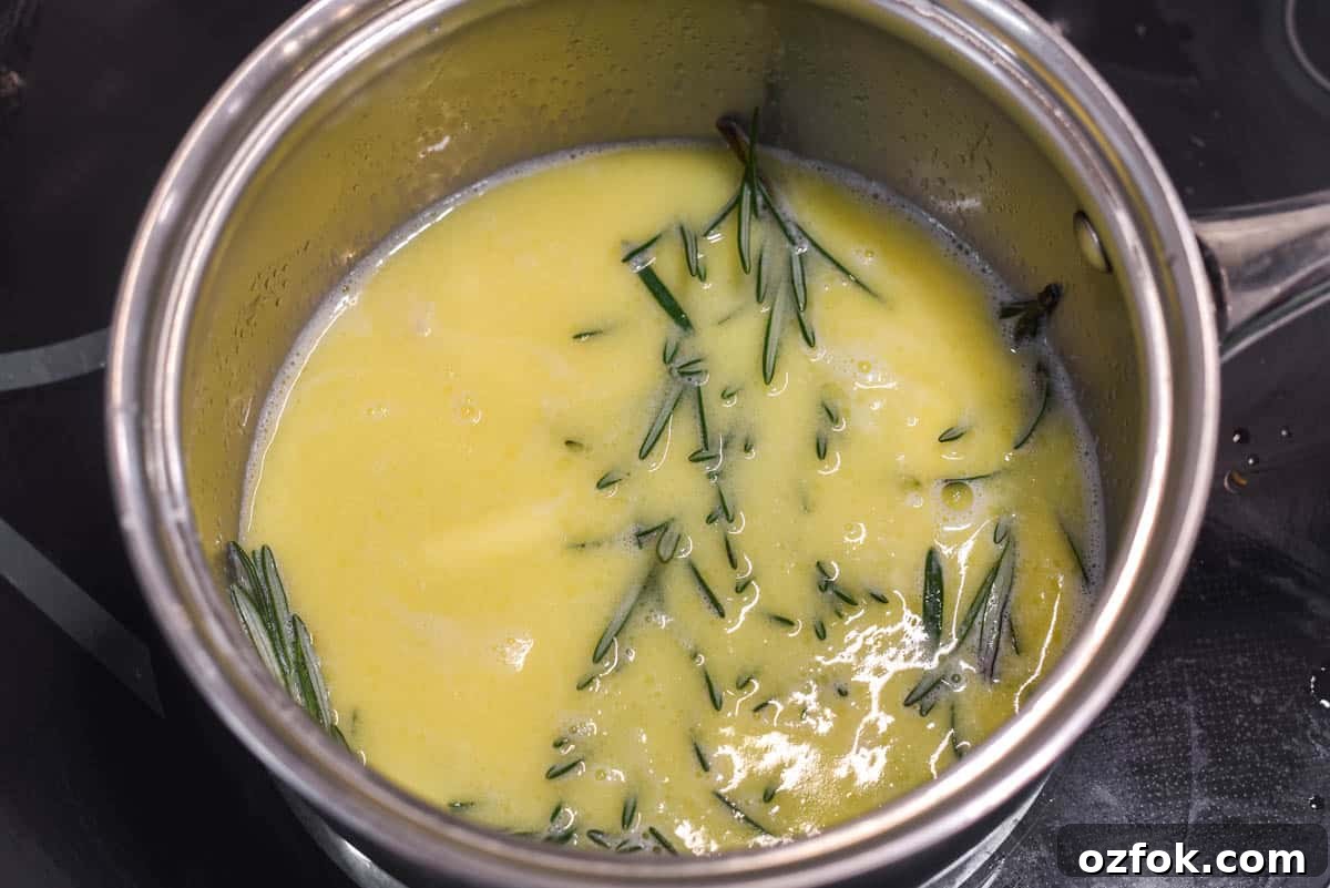 Infusing milk and butter with rosemary in saucepan.