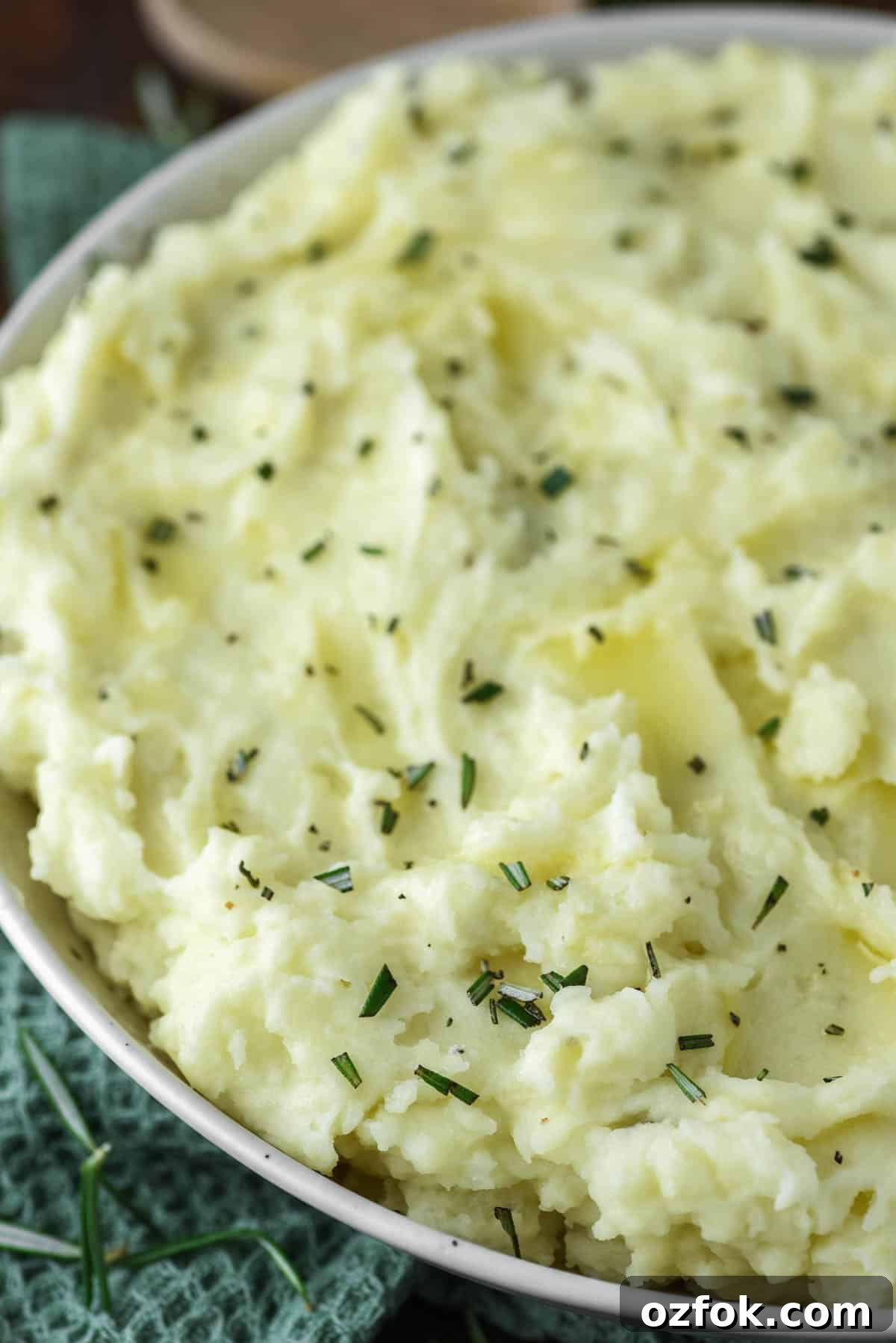 Rosemary mashed potatoes in bowl on dish towel.
