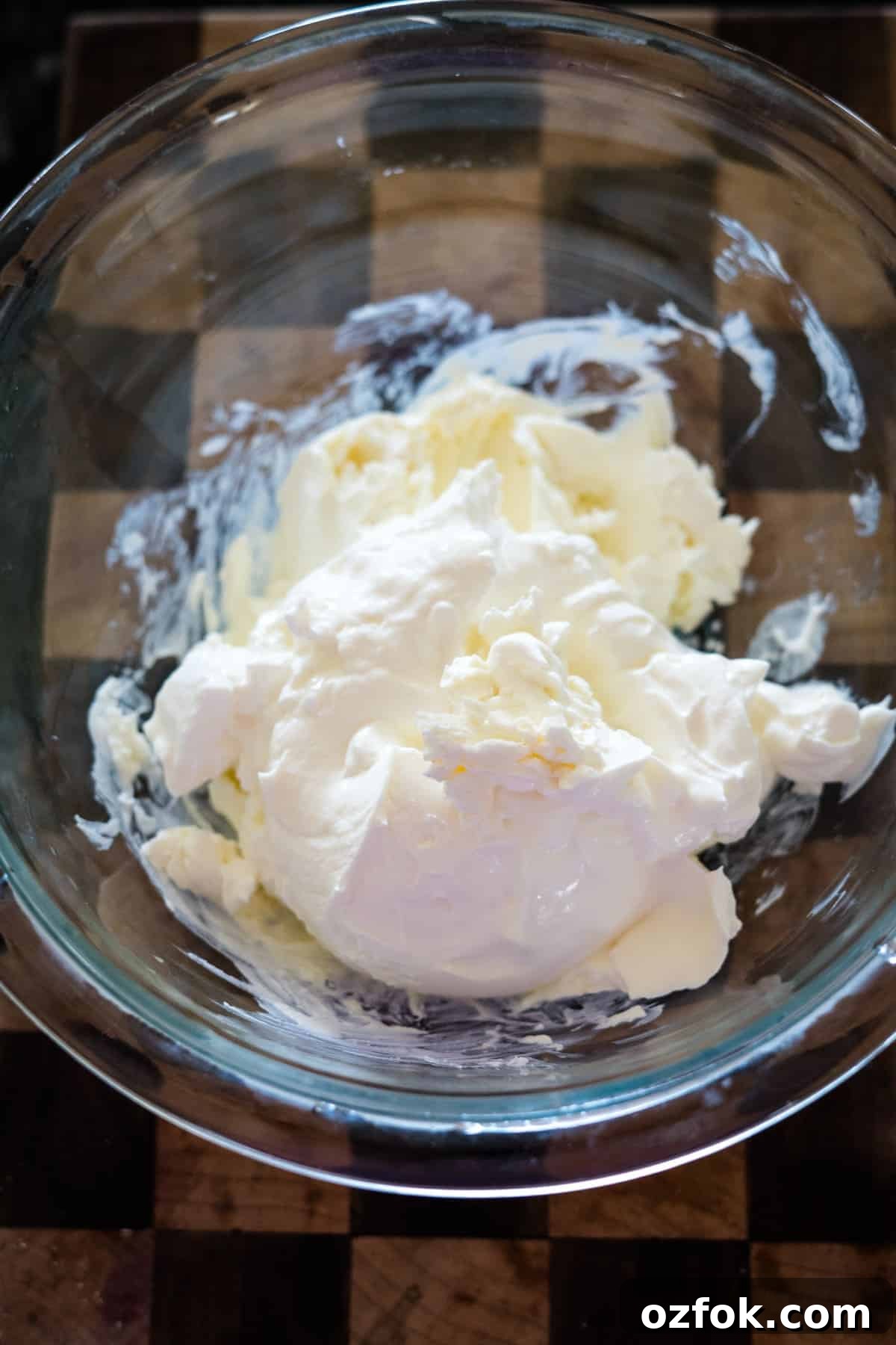 Keto French Onion Dip Recipe for Low-Carb Snacking 5 A glass bowl containing whipped cream on a wooden surface.