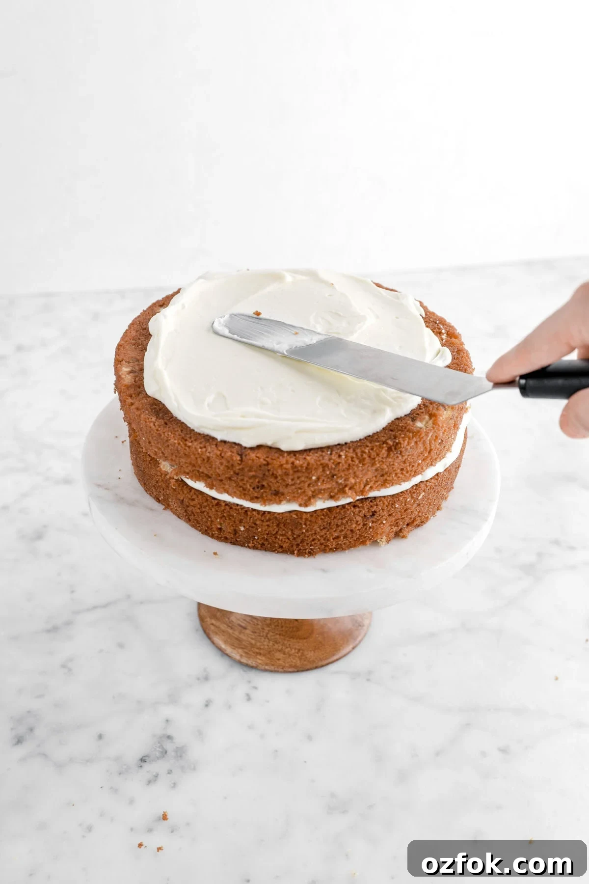 frosting being spread onto layered cake.