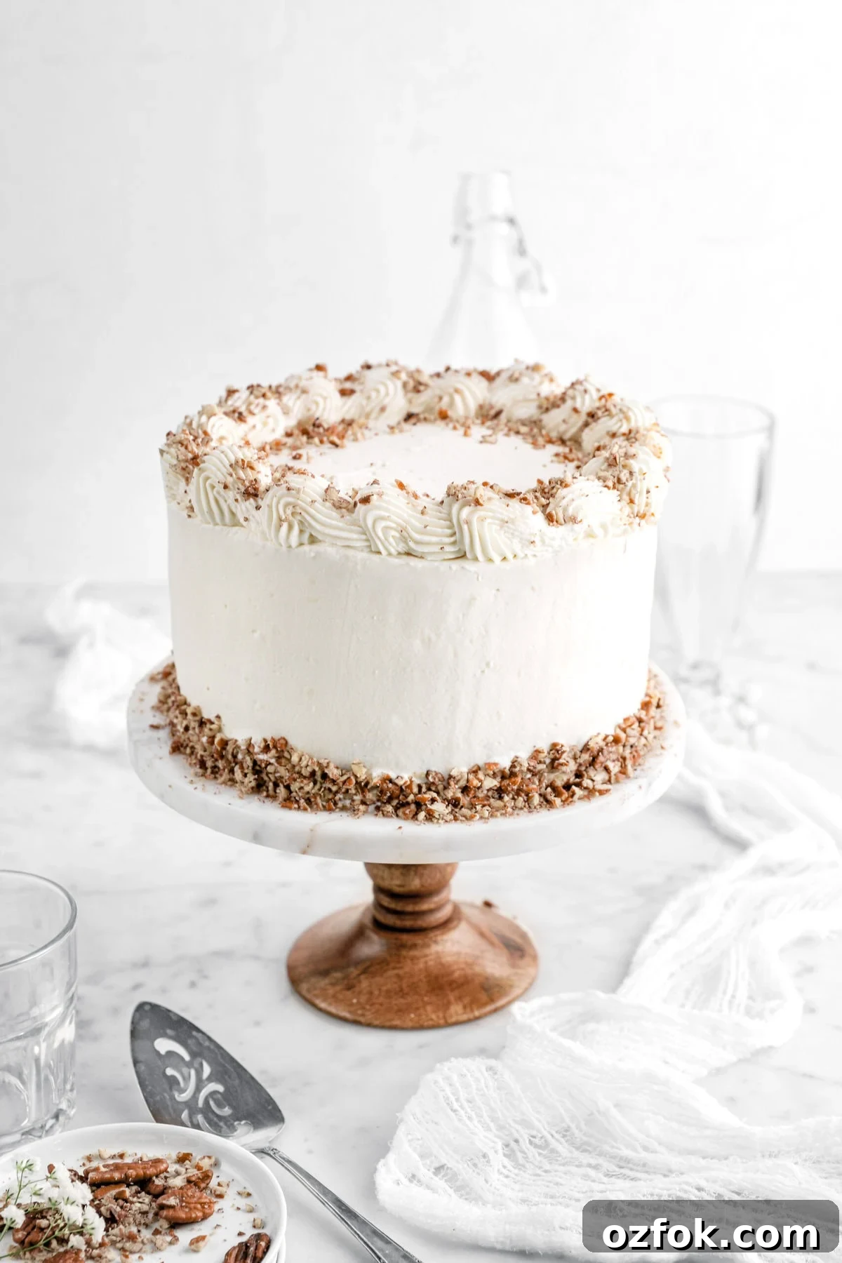 frosted hummingbird cake on marble cake stand.
