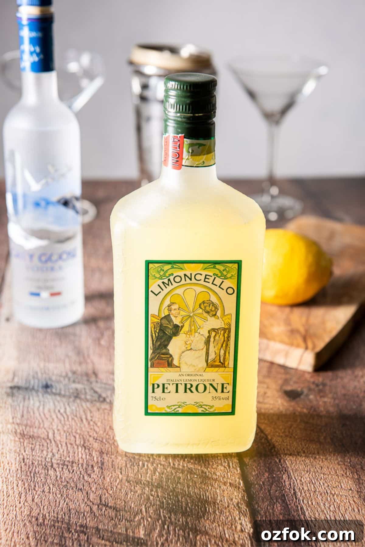 Sage Limoncello Martini Recipe — Citrus Cocktail with Herbal Twist 4 a table with limoncello, vodka, lemon and glasses and shaker
