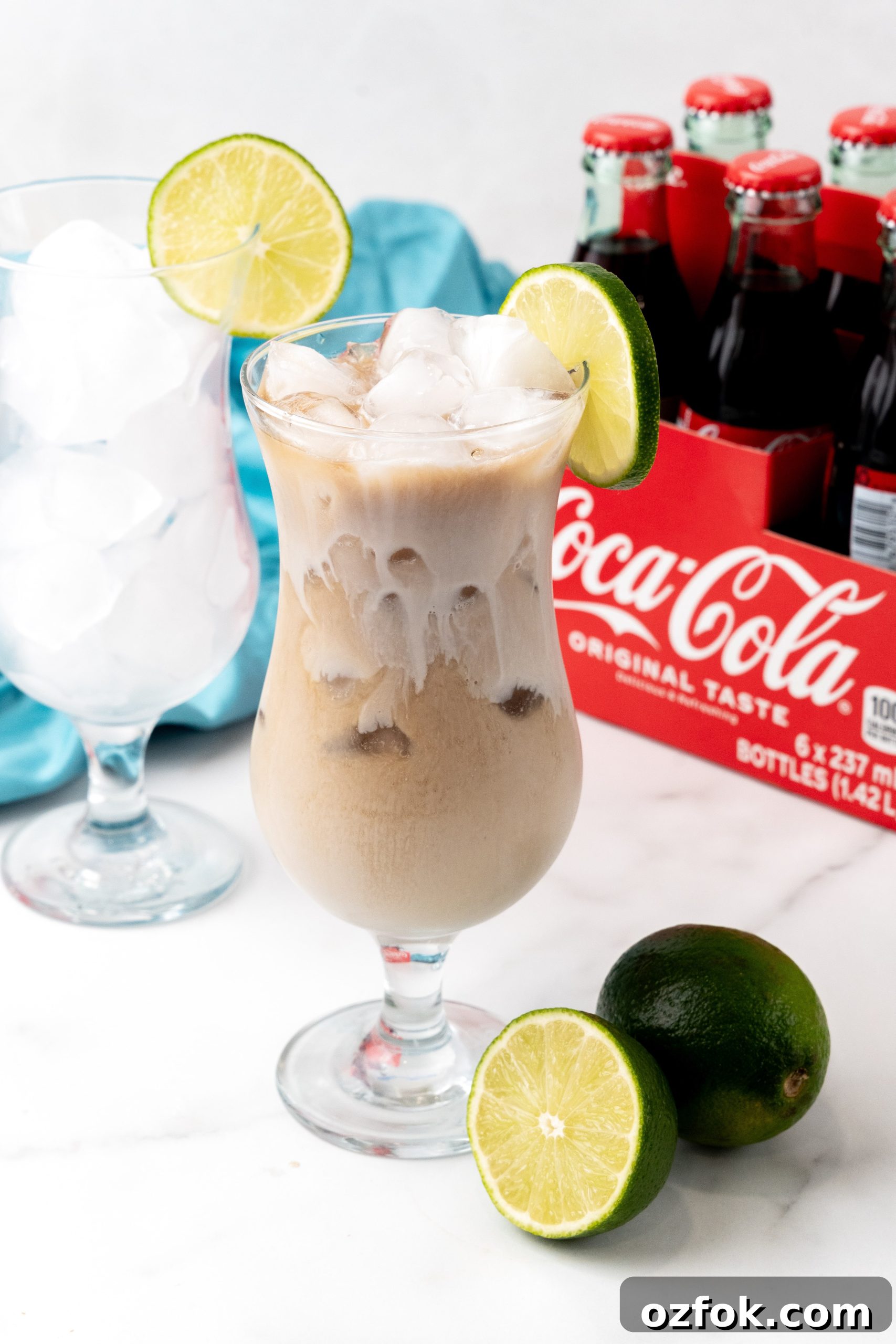 How to Make Viral Dirty Soda at Home: TikTok Recipe Guide 6 a dirty soda over ice in a daquiri style glass jar with a sliced lime resting on the rim
