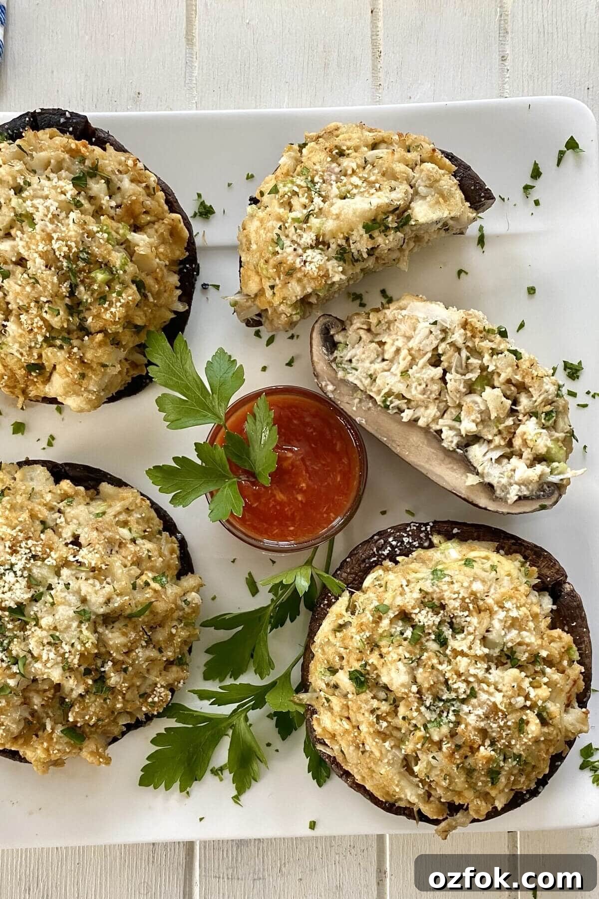 4 crab stuffed mushrooms with cocktail sauce.