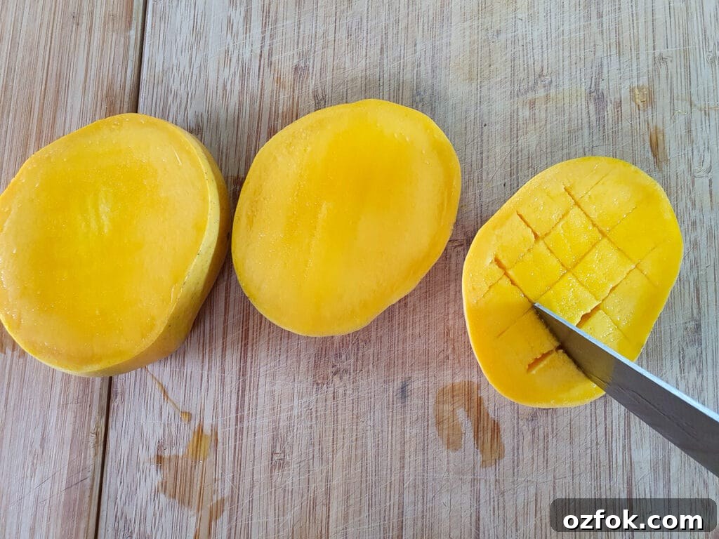 Creamy Mango Ice Cream Recipe: Fresh Mango Frozen Dessert 4 Slicing mango cheeks and scoring them into a grid pattern.