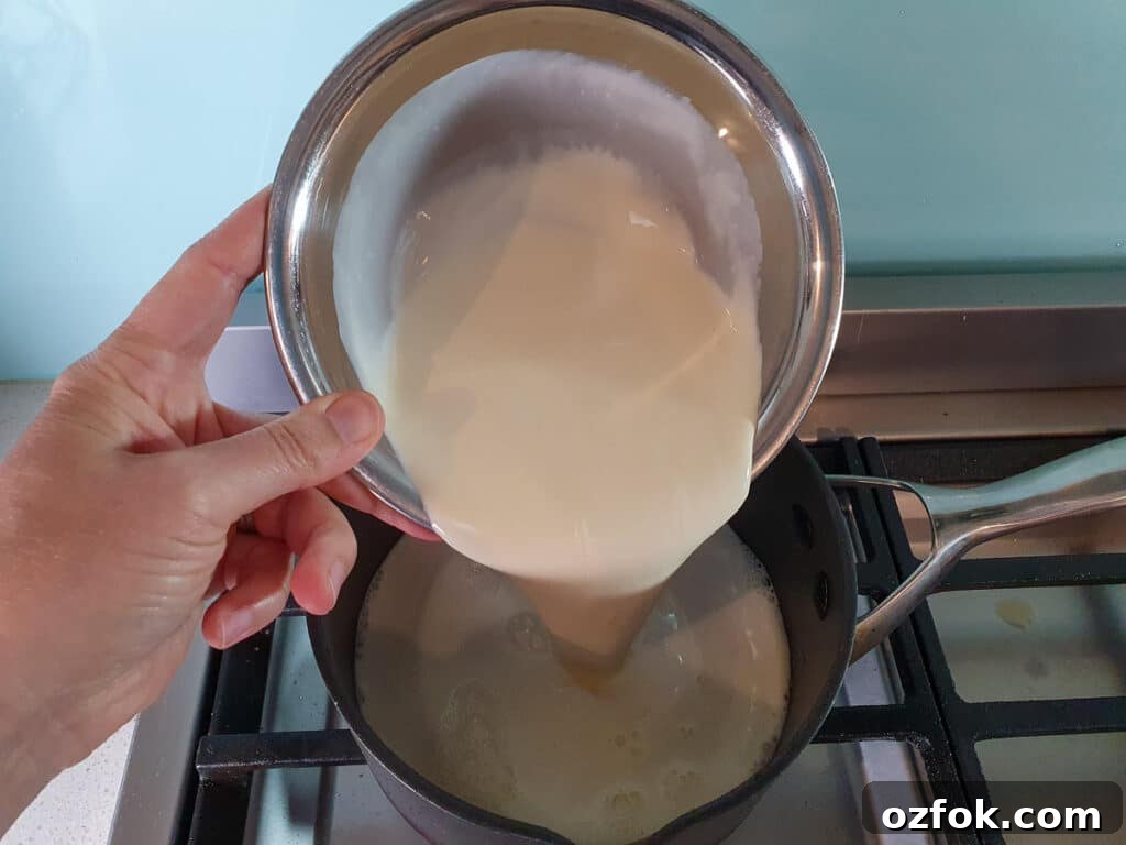 Creamy Mango Ice Cream Recipe: Fresh Mango Frozen Dessert 9 adding cream to pot on stove.