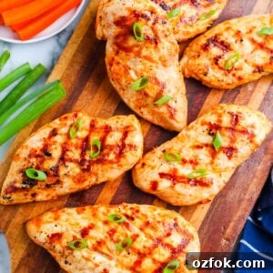 Grilled Buffalo Chicken Breasts with Tangy Blue Cheese Dip 7 Grilled buffalo chicken breasts arranged on a wooden cutting board with green onions, carrots, celery, and ranch dressing.