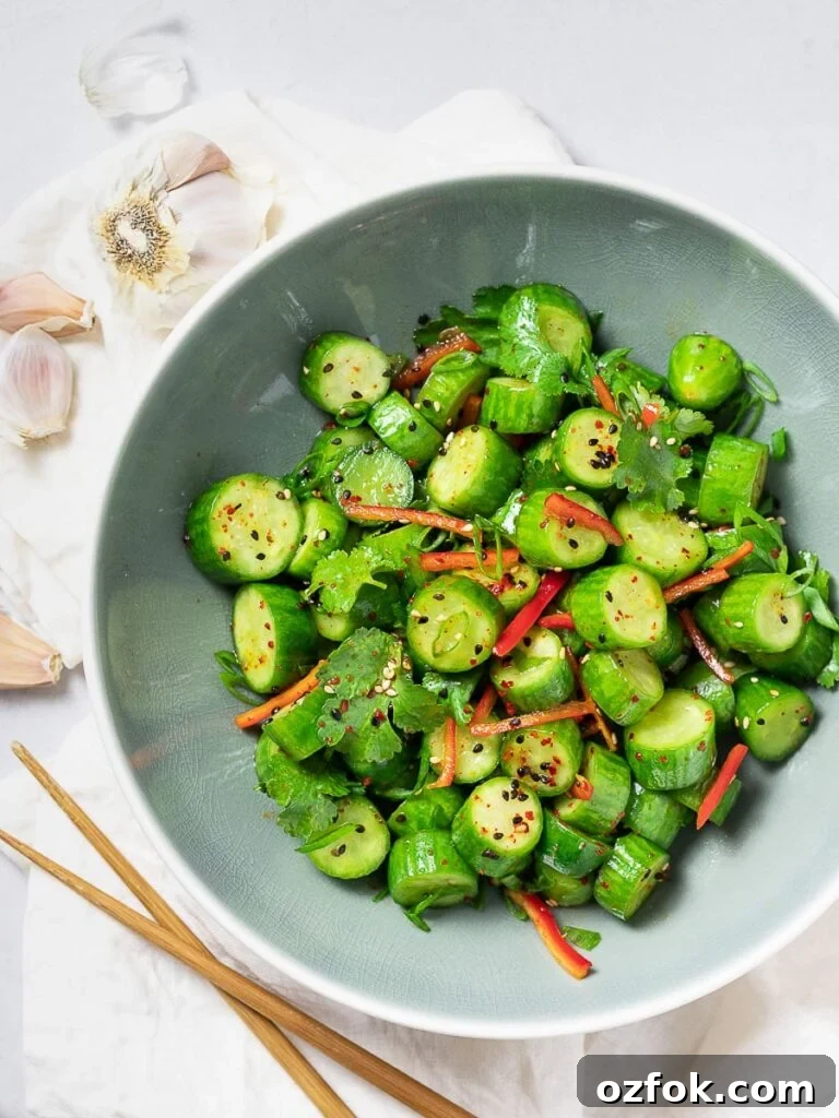 Spicy Korean Radish Salad (Musaengchae) — Authentic Recipe 12 Spicy Asian cucumber salad with herbs and red pepper in a blue bowl next to garlic and chopsticks