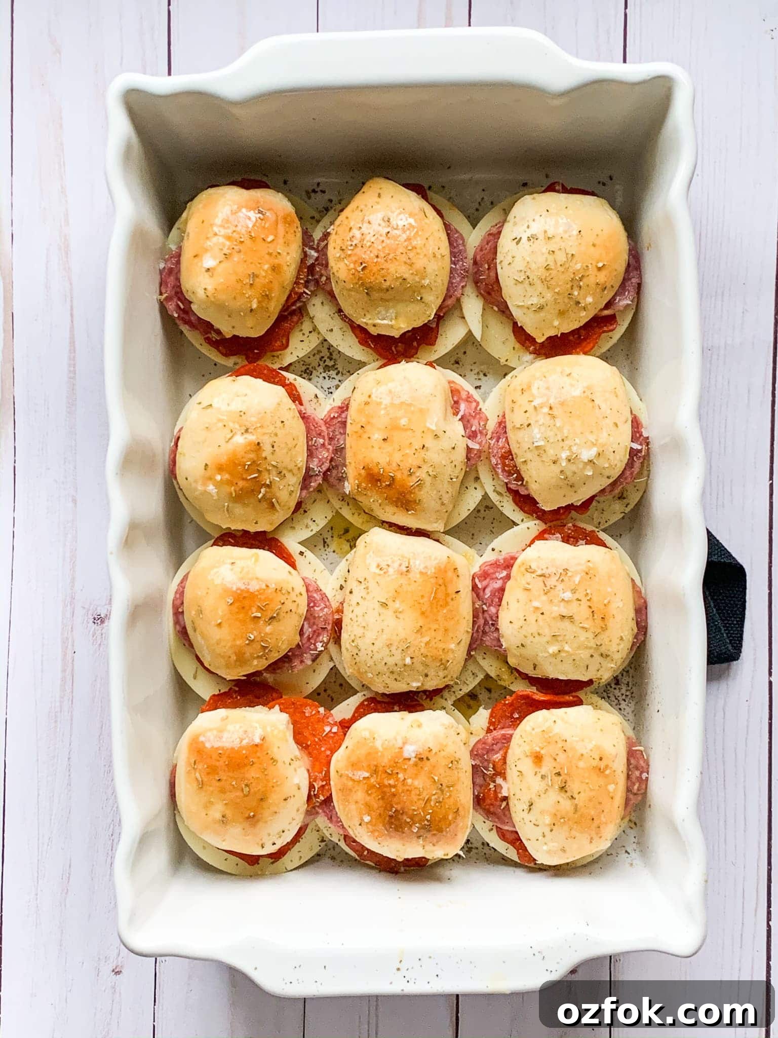Italian Slider Recipes: Flavorful Mini Sandwiches for Entertaining 2 Baked Italian sliders in a white baking dish.
