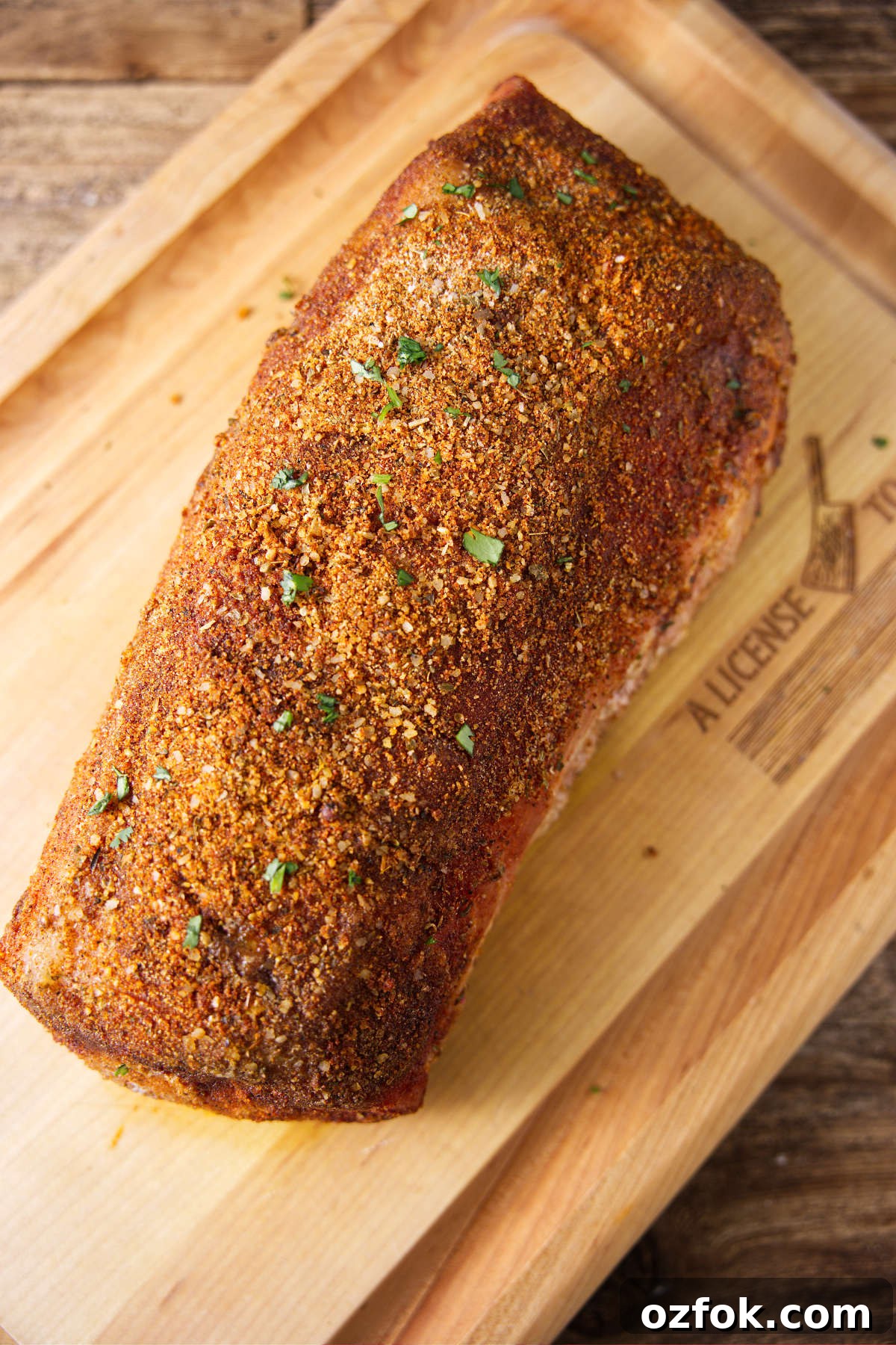 Smoked pork loin resting on wood cutting board.