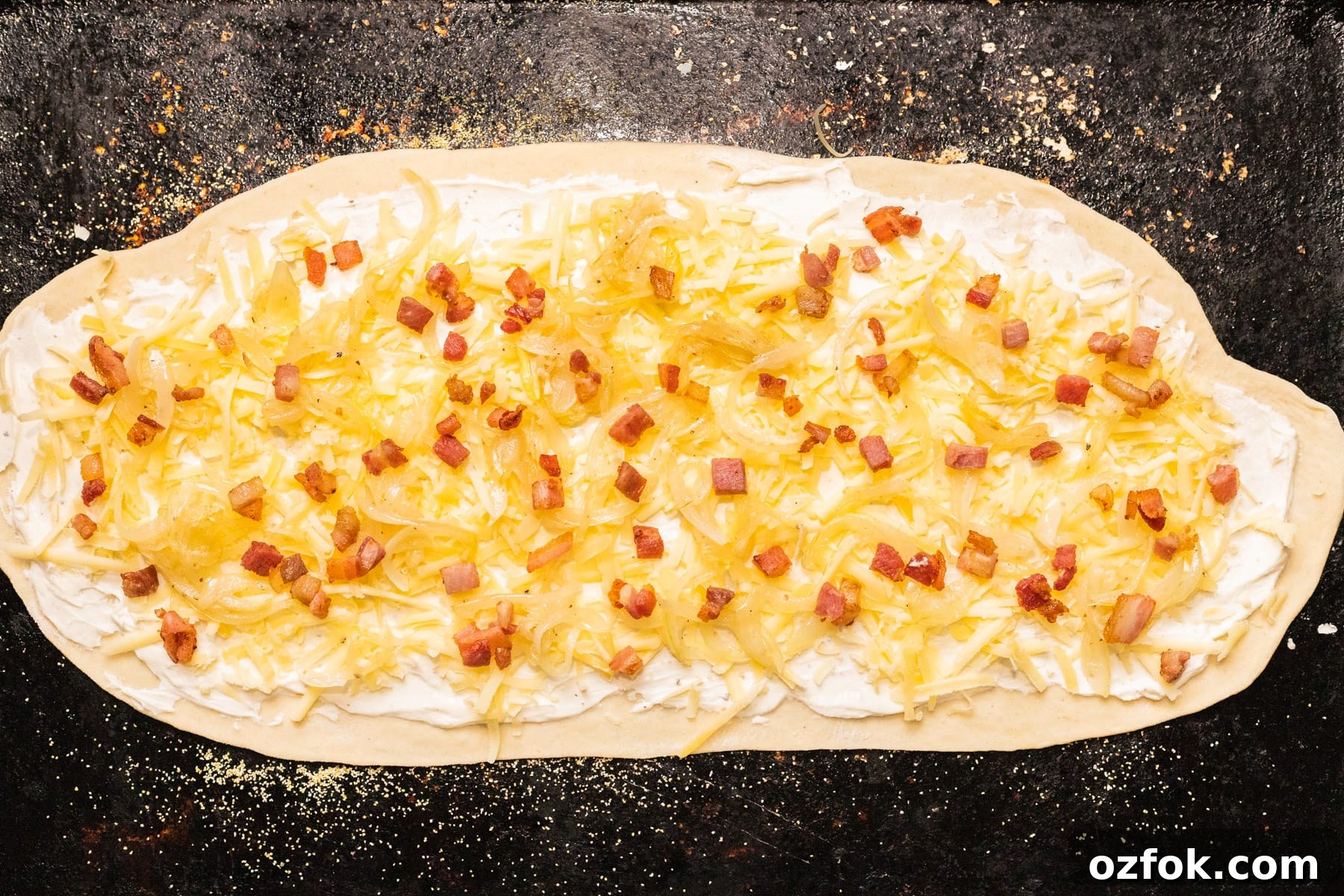 Flammkuchen: Authentic German Tarte Flambée Recipe and Tips 4 A top down view of unbaked flammkuchen on a baking sheet.