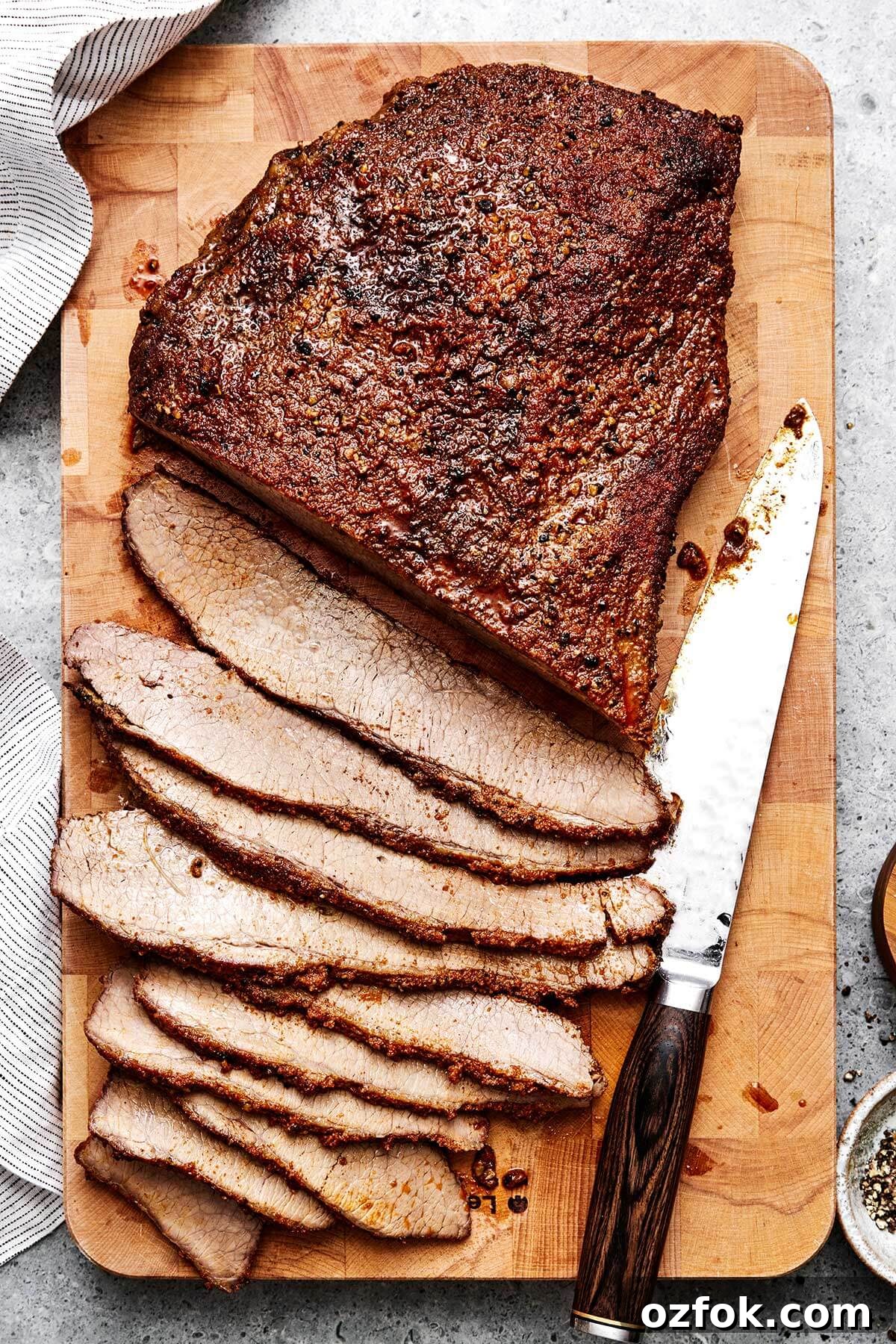 Sliced beef brisket on a wooden board.