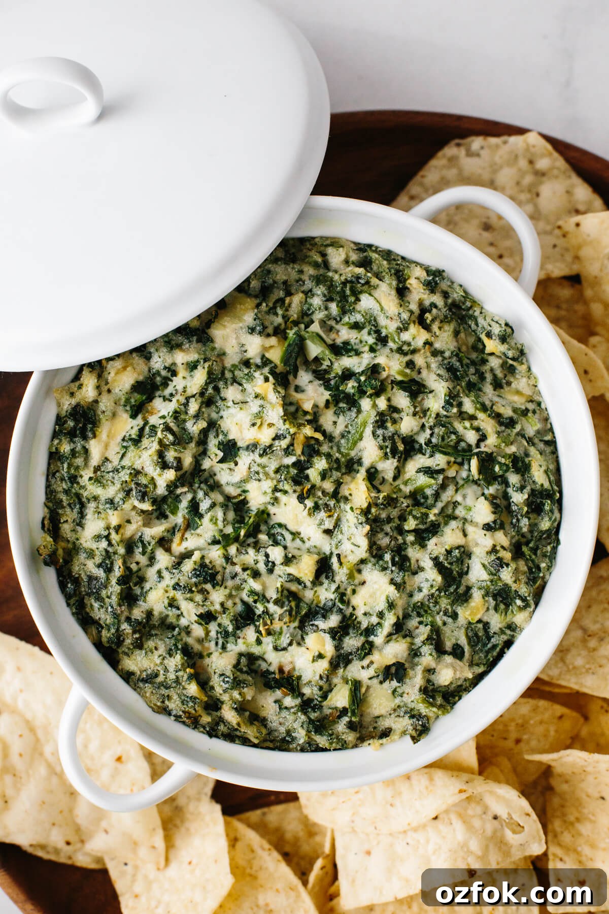 Spinach artichoke dip in a white casserole dish.