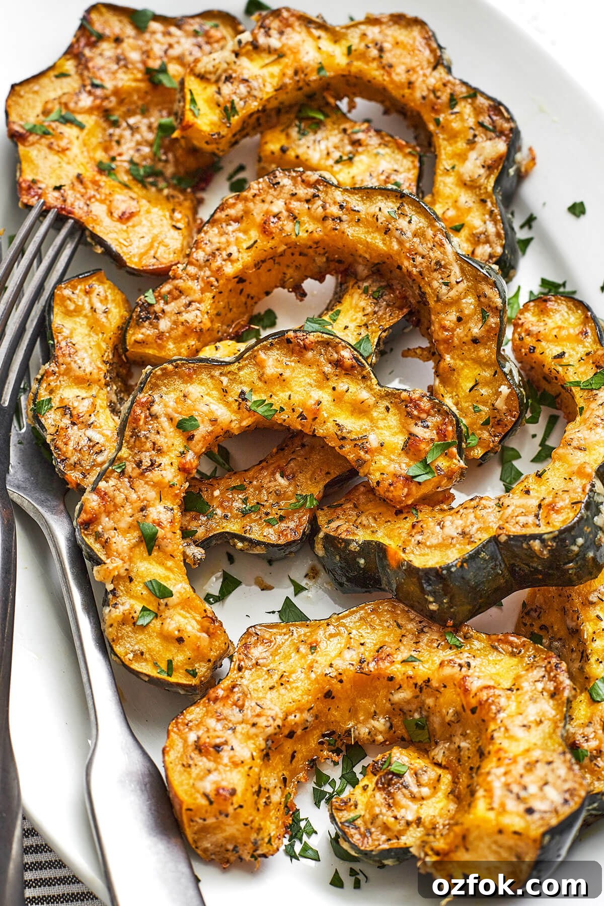 Parmesan herb roasted acorn squash on a platter with a fork