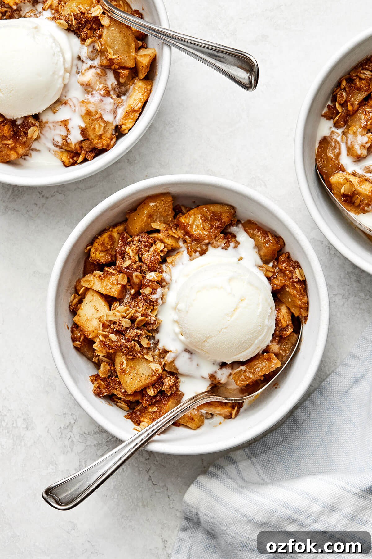 Bowls of apple crisp with ice cream.