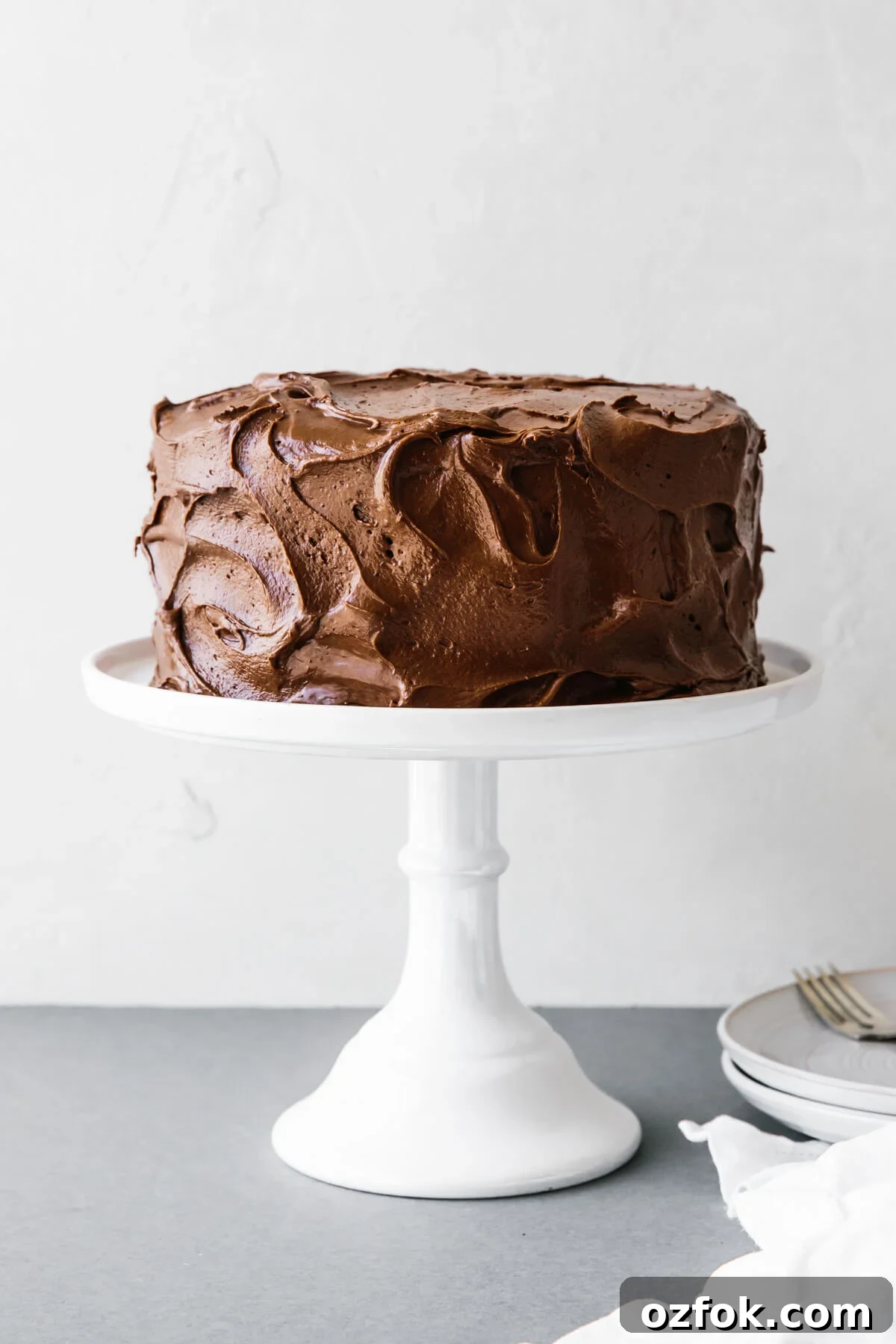 Paleo chocolate cake on a white cake stand.
