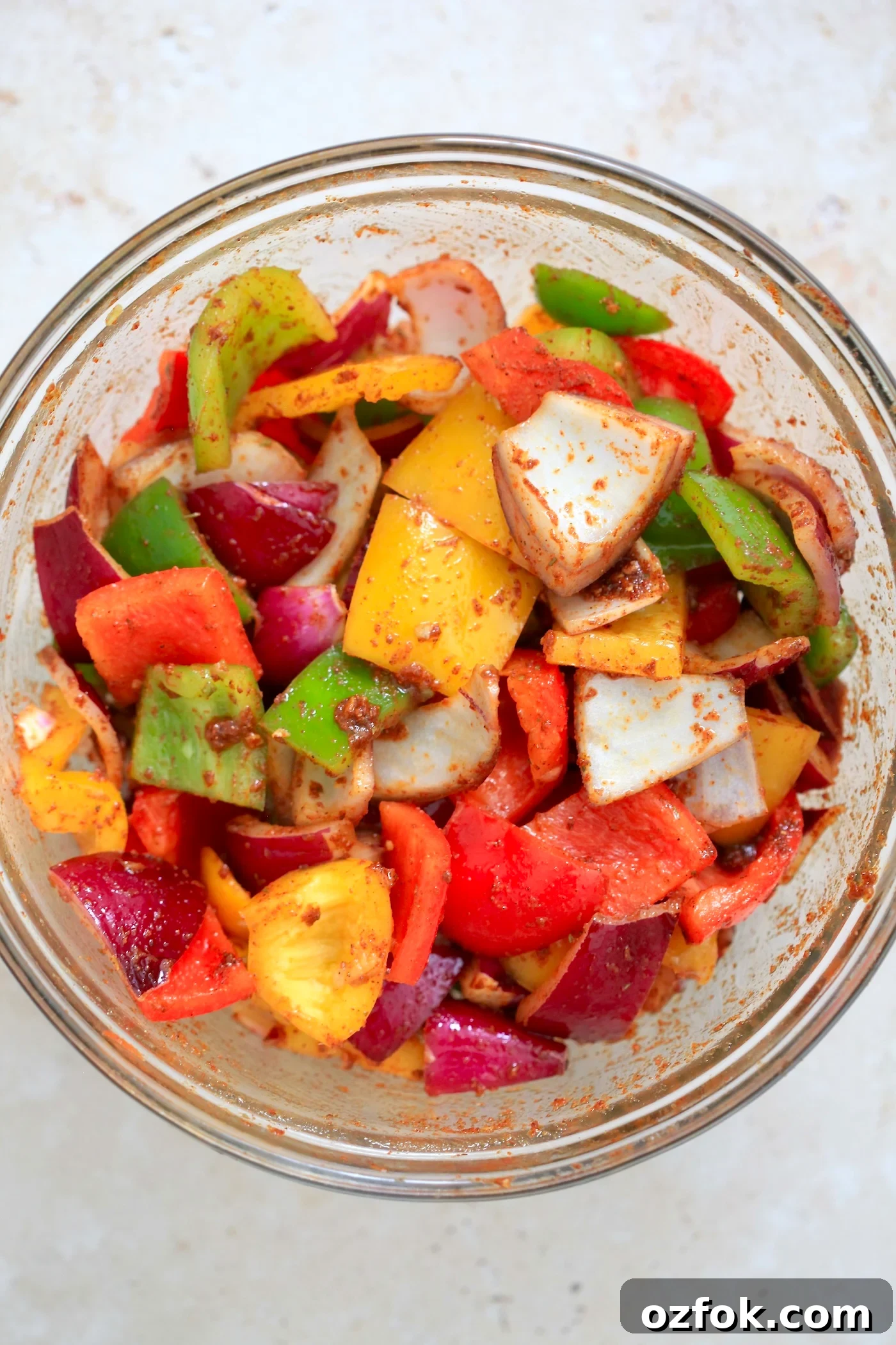 Flavor-Packed Baked Tofu Fajitas with Roasted Veggies 4 chopped peppers and onion with brown marinade in mixing bowl