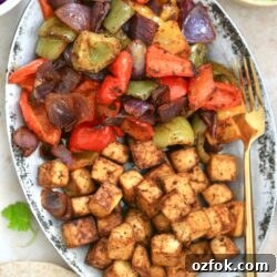 silver platter with brown cubes and cooked peppers.