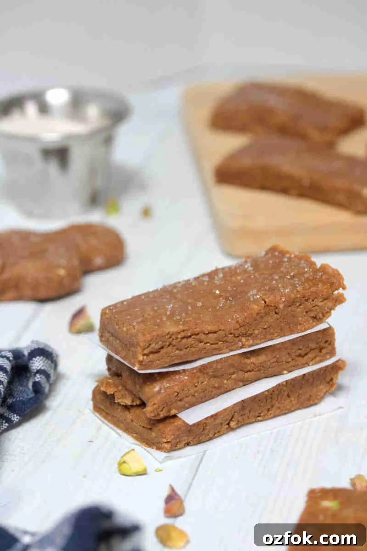 5-Minute Gingerbread Protein Bars Recipe for Quick Snacks 2 Three gingerbread protein bars stacked with parchment paper between them and pistachios around them.