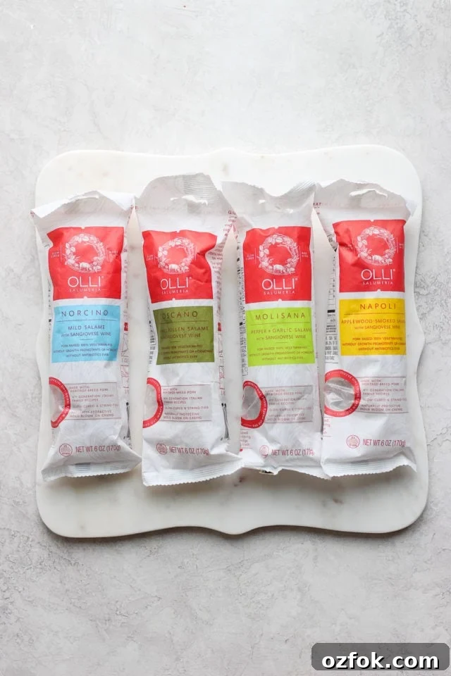 Olli Salumeria Assorted Salami Mix Four packages of salame on a marble stone.