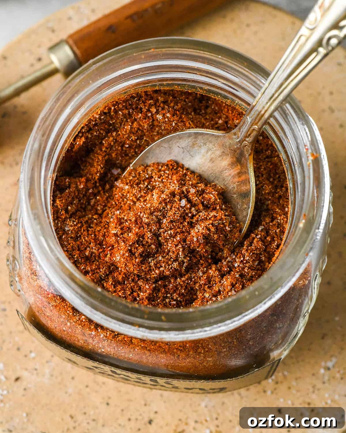 Homemade Chili Seasoning Blend for Bold, Authentic Flavor 3 a spoon in a jar of Homemade Chili Seasoning Recipe