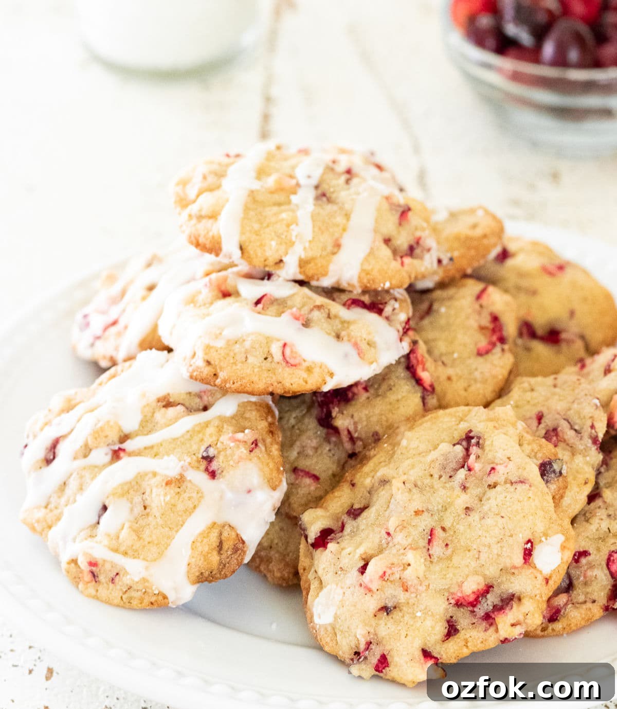 Cranberry Pecan Cookies with Old-Fashioned Flavor 2 Soft cranberry pecan cookies with orange glaze stacked on a white plate
