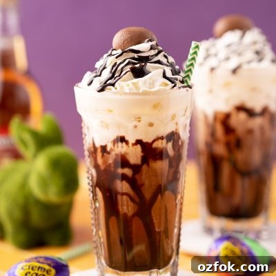 Crème Egg Dirty Soda Recipe: Candy-Inspired Creamy Fizzy Drink 7 A Cadbury Creme Egg flavored dirty soda on a white coaster on a yellow table.