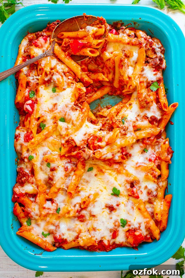Cheesy Ravioli Lasagna Recipe: Layered Baked Pasta with Marinara 15 Cheesy Beef and Pasta Casserole in a baking dish with a spoon on top.