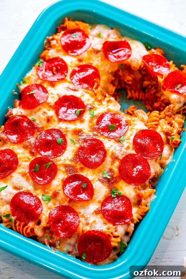 Cheesy Ravioli Lasagna Recipe: Layered Baked Pasta with Marinara 16 Pizza Pasta Casserole in a baking dish with a scoop missing.