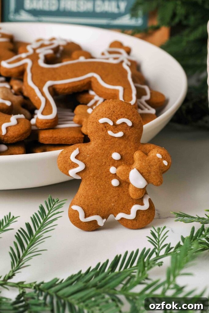 A gingerbread man holds a mini gingerbread baby.
