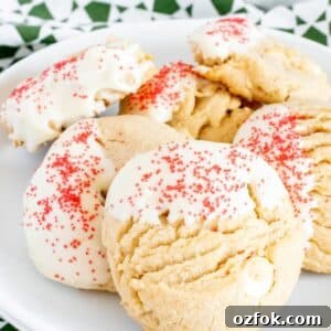 White Chocolate Peanut Butter Cookie Recipe for Chewy Cookies 10 Peanut butter white chocolate chip cookies decorated with red sprinkles on a white plate.