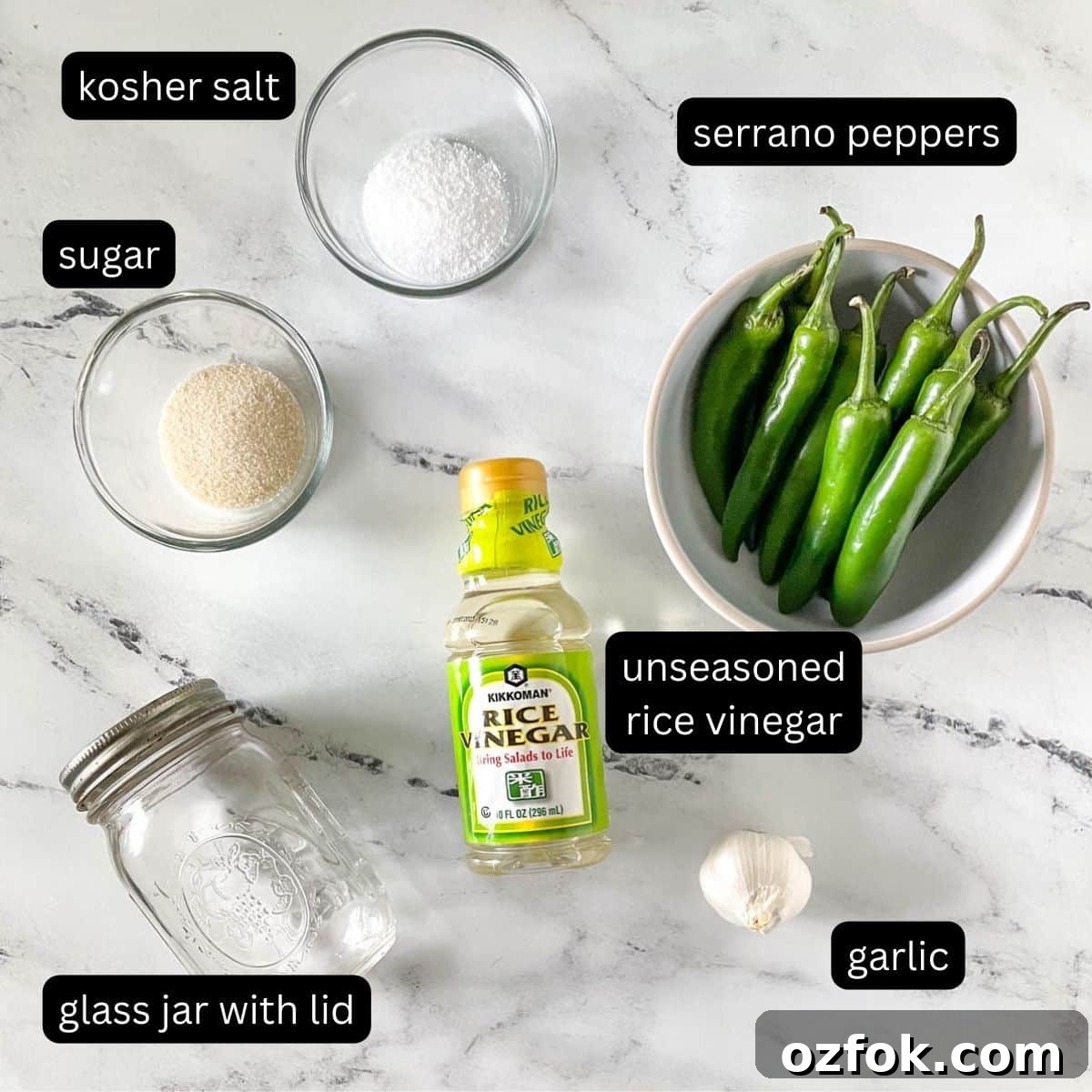 Quick Pickled Serrano Peppers Recipe for Tangy, Crisp Jalapeño-Style Peppers 3 The labeled ingredients for pickled serrano peppers are shown on a white marble counter.