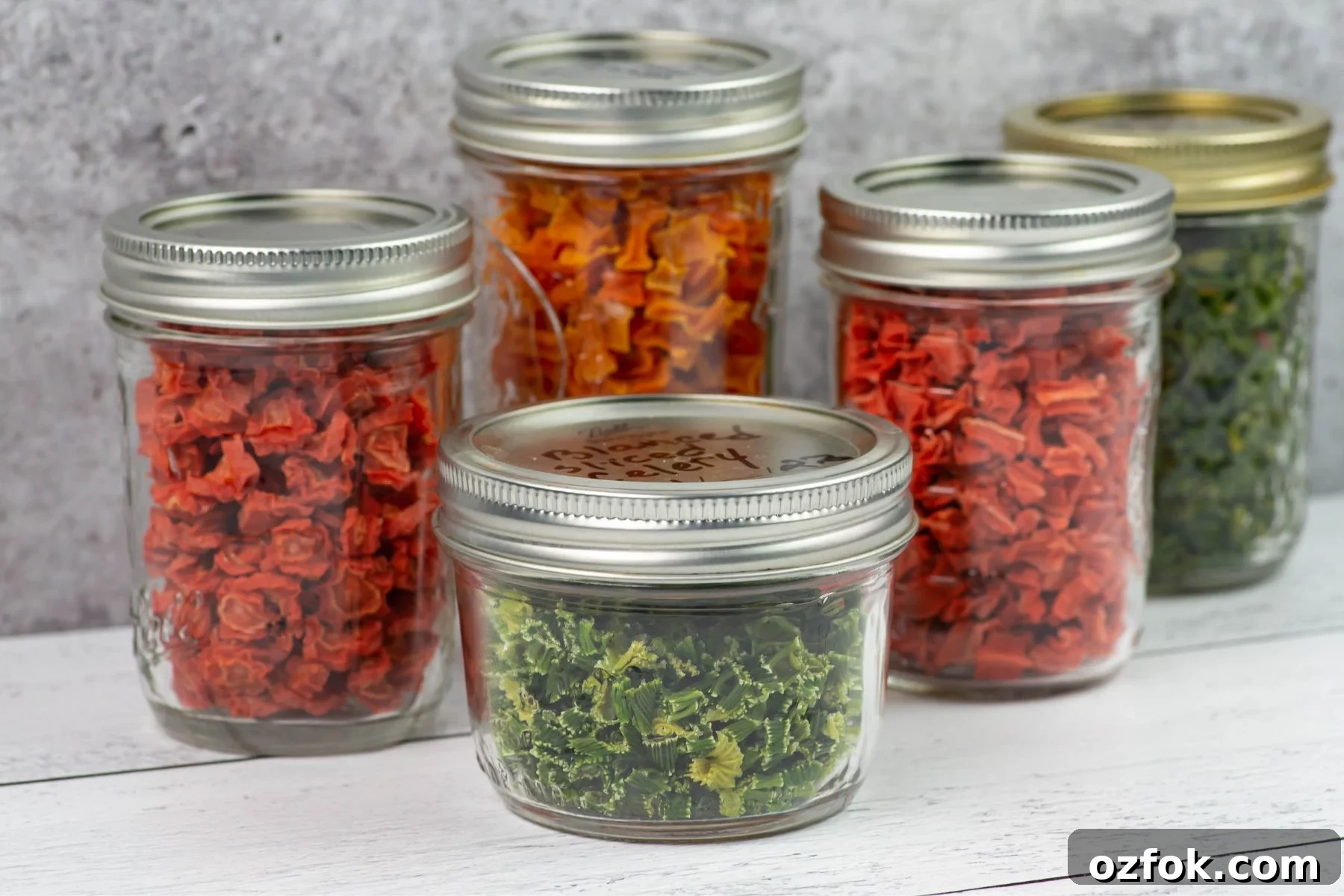 Dehydrating Celery: Step-by-Step Guide for Crispy, Long-Lasting Stalks 6 Dehydrated celery in a small mason jar with other glass jars of dried vegetables in the background.
