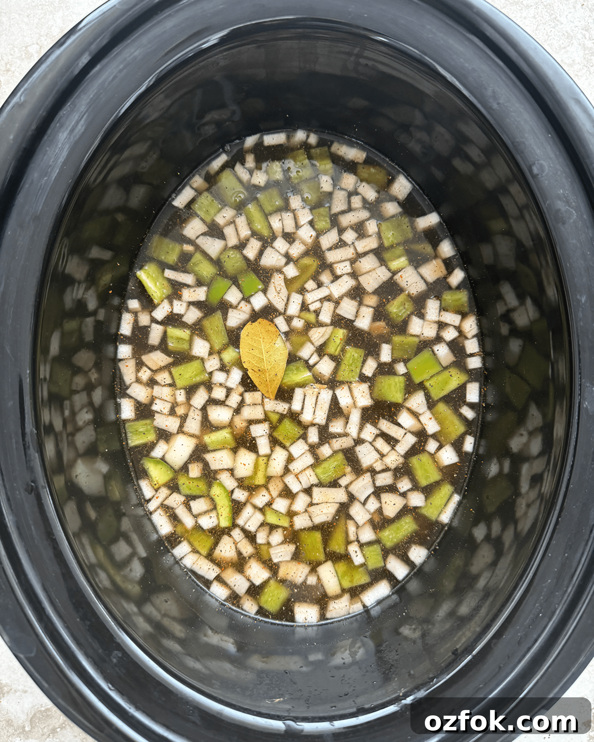 overhead shot of uncooked mexican black beans and rice in a black slow cooker