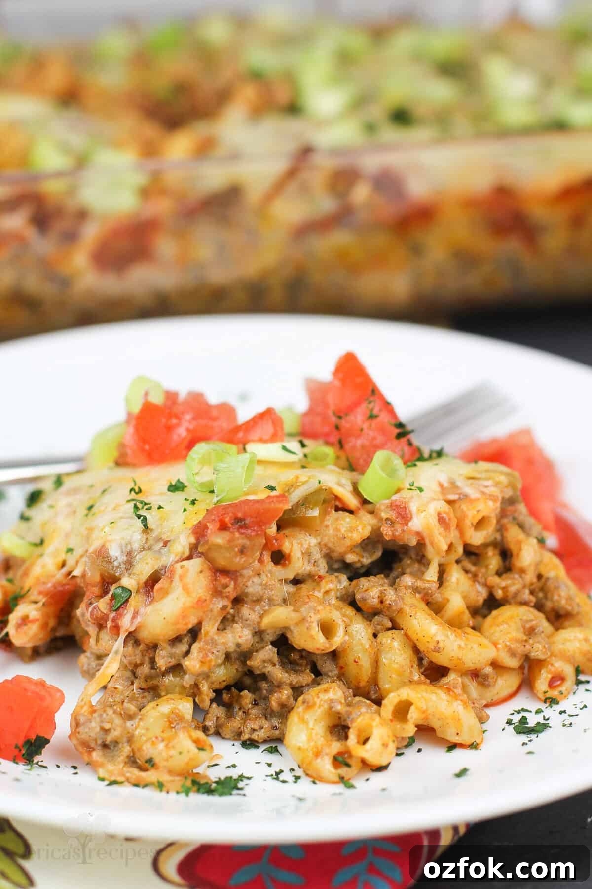 Taco Beef and Macaroni Casserole: Cheesy One-Pan Dinner 7 plated recipe on white dish with casserole in background