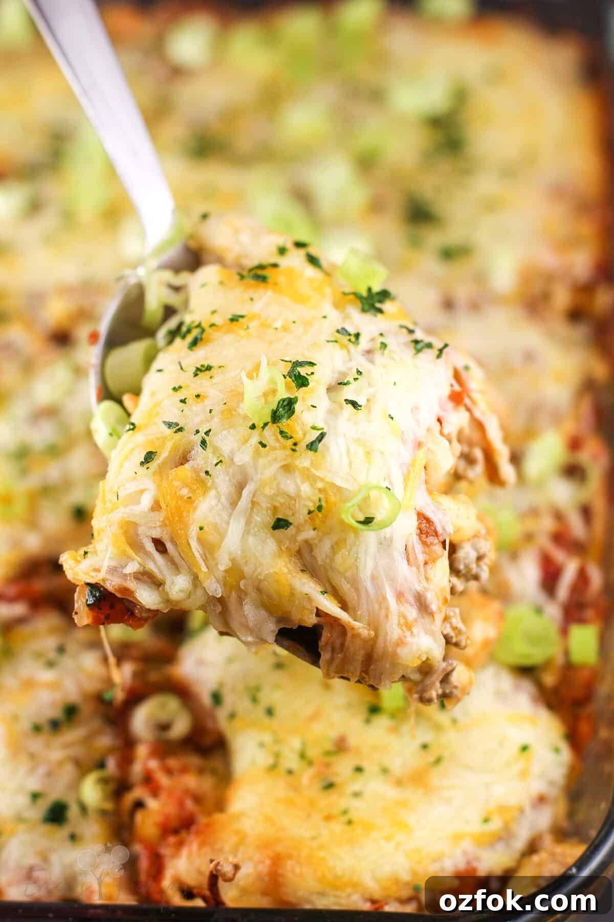 Taco Beef and Macaroni Casserole: Cheesy One-Pan Dinner 8 spoon lifting casserole over dish