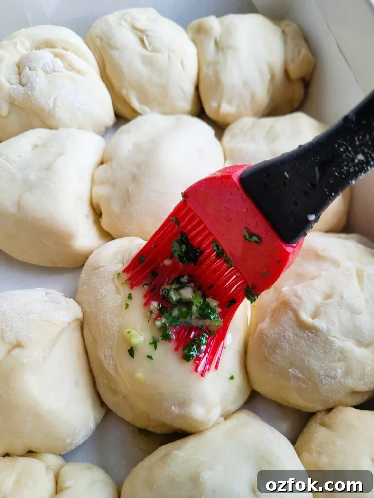30-Min Garlic Parmesan Dinner Rolls Recipe 5 Brushing dinner rolls with melted garlic butter before baking