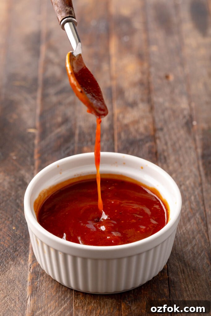 Sweet and Spicy Barbecue Sauce Recipe for Grilling and Dipping 4 bowl of sweet & spicy bbq sauce with a spoon dripping sauce