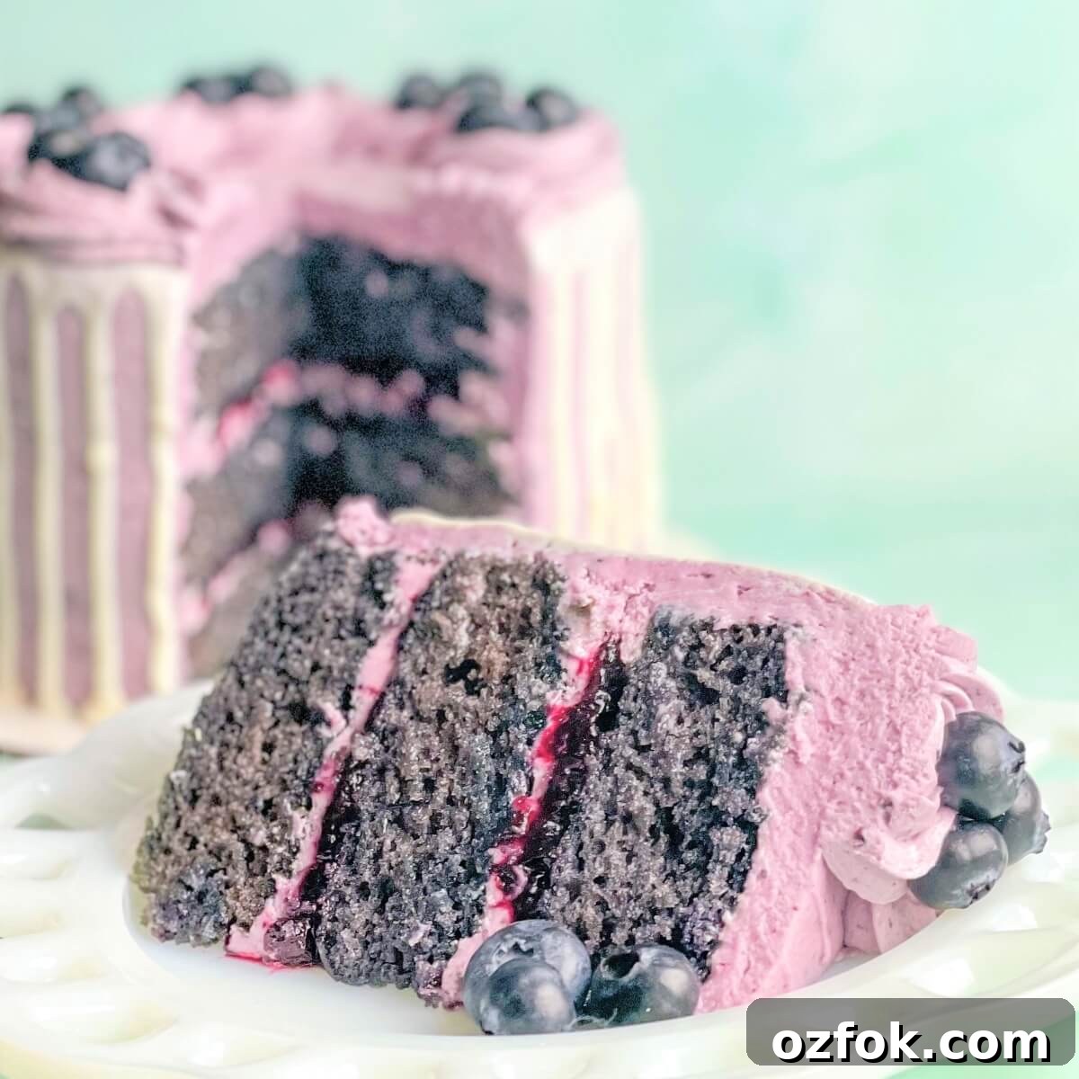 A slice of fresh blueberry cake with blueberry cake filling and blueberry buttercream