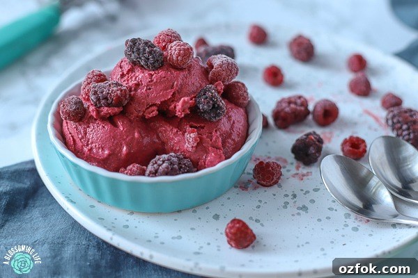5-Minute Homemade Frozen Yogurt Without an Ice Cream Maker 7 homemade frozen yogurt in a teal dish topped with blackberries and raspberries on a white speckled plate