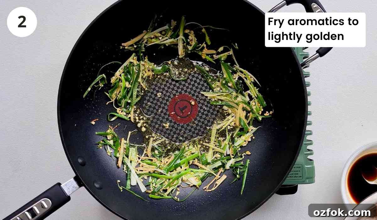 Chinese-Style Prawn Stir-Fry with Ginger and Spring Onions 6 finely sliced ginger, spring onions and garlic in a wok with caption