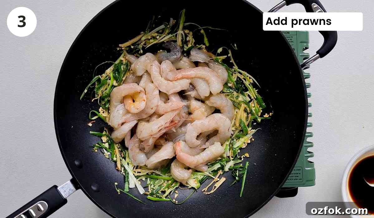 Chinese-Style Prawn Stir-Fry with Ginger and Spring Onions 7 peeled raw prawns in a large wok with caption