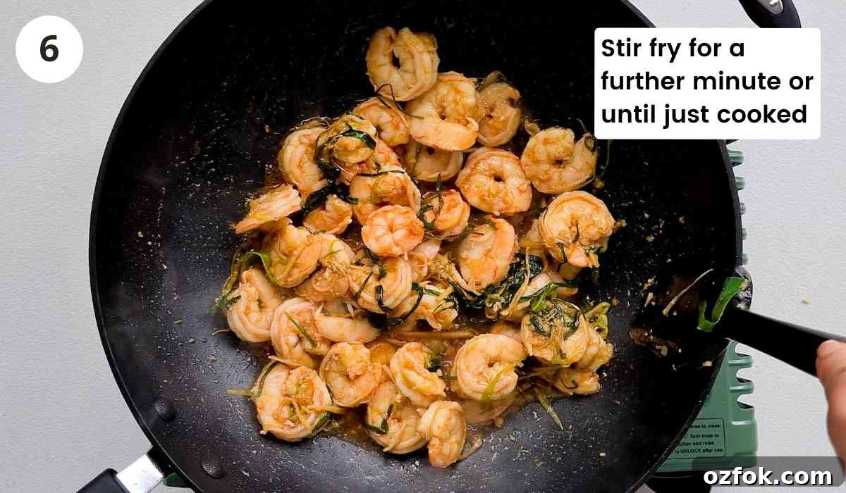 Chinese-Style Prawn Stir-Fry with Ginger and Spring Onions 10 Cooked Chinese prawn stir fry in a large wok with caption
